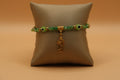 Dangling San Judas lime green evil eye bracelet